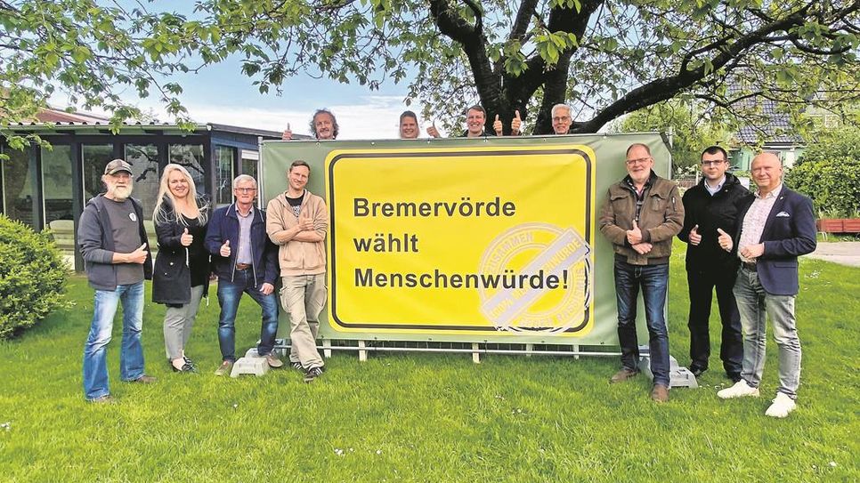 Kathrin Nübel (sechste von links), Bürgermeister Hannebacher (rechts), einige Ortsvorsteher der Bremervörder Ortschaften sowie weitere an der Aktion beteiligte Personen präsentieren das Banner.