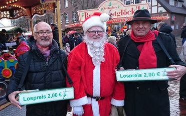 Die beiden Losverkäufer nutzten die Gelegenheit, sich einmal im Leben mit dem Weihnachtsmann ablichten zu lassen. Foto: eb