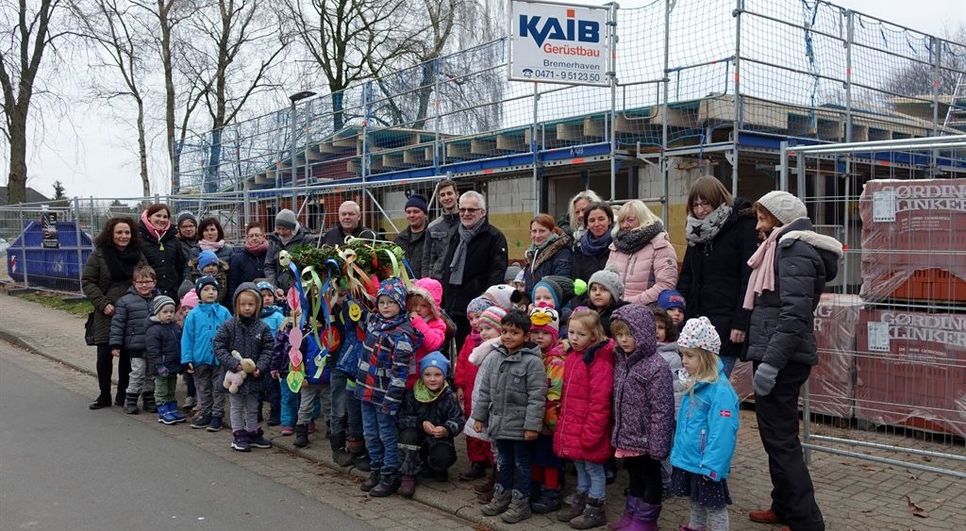 „Wir feiern heut‘ ein Fest.“ Das Richtfest für den Krippenanbau wurde mit einem selbst gebastelten Richtkranz gefeiert.  Foto: khe