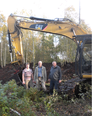 Im Gelände unterwegs vor einem neuen Kranichbiotop: Vera Meyn, Kirchenvorstandsmitglied, Baggerfahrer Rainer Detjen und Projektbeauftragter Bernd Rathjen. Foto: eb