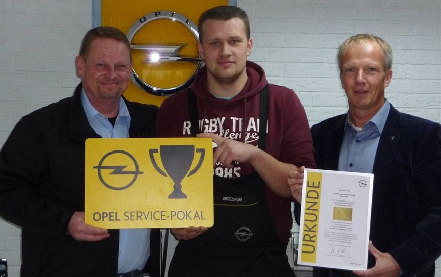 Alexander Neuber (li.) übergibt den Opel Service-Pokal an Servicetechniker Martin Brezinski und Serviceberater Marco Sinn.  Foto: eb