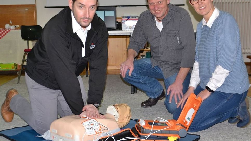 Sascha Feldt zeigt Rolf Gerlach und Alke Meyer, wie der Defibrillator zu bedienen ist (von links). 
 Foto: ui