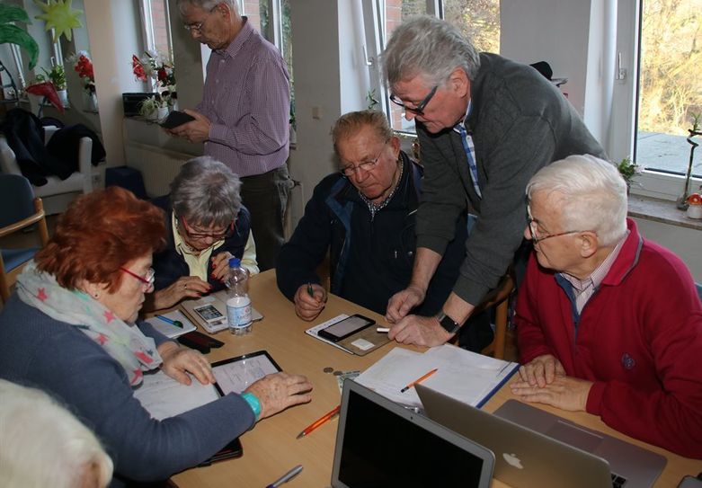 Klaus Reichenbach (2.v.li), Leiter der MAC-Gruppe Ritterhude, erklärt Anwendungen auf dem Ipad und Iphone. Foto: sr