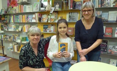 Clara las in der Schatulle von Sabine (li.) und Ute (re.) Gartmann aus ihrem Buch „Honigkuckuckskinder“.  Foto: hc