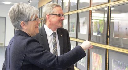 Jutta Rühlemann und Bernd Lütjen betrachten die aktuelle Ausstellung im Kreishaus mit Arbeiten aus dem letzten Fotowettbewerb, der sich mit Flora und Fauna im Landkreis beschäftigte.  Foto: jm