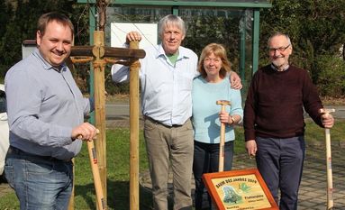 Julian Fischer, die Paten Eckard und Cerry Ziel sowie Heino Hühnken (v.li.) präsentieren das neu errichtete Baumschild neben dem frisch gepflanzten Baum des Jahres in Lübberstedt. Foto: Eike-Rolf Michael