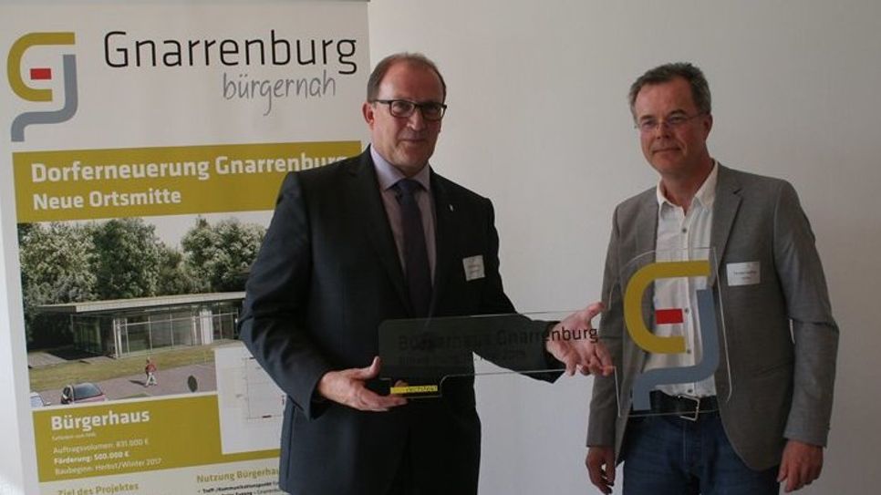 Bürgermeister Axel Renken nahm stolz von architekt Torsten stelling (r.). den Schlüssel für das Bürgerhaus entgegen. Foto: af