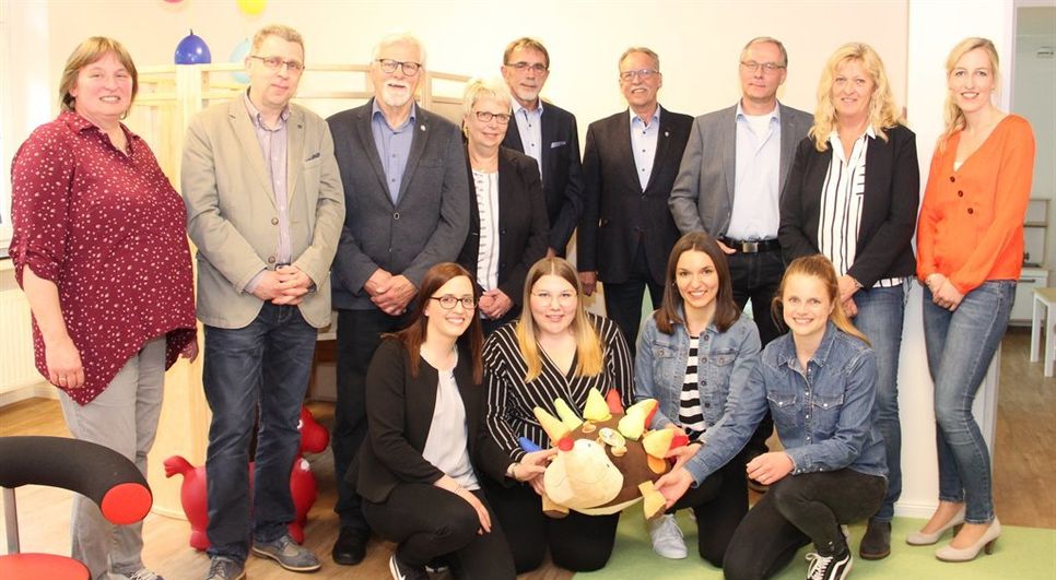 Freuen sich über die erfolgreiche Partnerschaft in Sachen neuer Krippengruppe: Samtgemeindebürgermeister Gerhard Kahrs (hinten, 3.v.r.), Bürgermeister Reinhard Aufdemkamp (hinten 4.v.r.), Helge Richter, Vorstandsvorsitzender der Lebenshilfe (hinten Mitte), Marlies Gresens, Geschäftsführerin (2.v.r.), hier zusammen mit Mitgliedern ihres Teams und weiteren Vertretern des Vorstandes der Lebenshilfe. Im Vordergrund die vier pädagogischen Fachkräfte, die die neue Krippengruppe betreuen: Eva Grabau, Eva Holsten, Christin Poppe und Friederike Peick (.l.).  Foto: ue