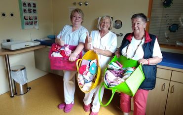 Schwester Carmen Cordes und Kerstin Säland nahmen von Karin Nehring die getrickten Mützen in Empfang. Foto: eb