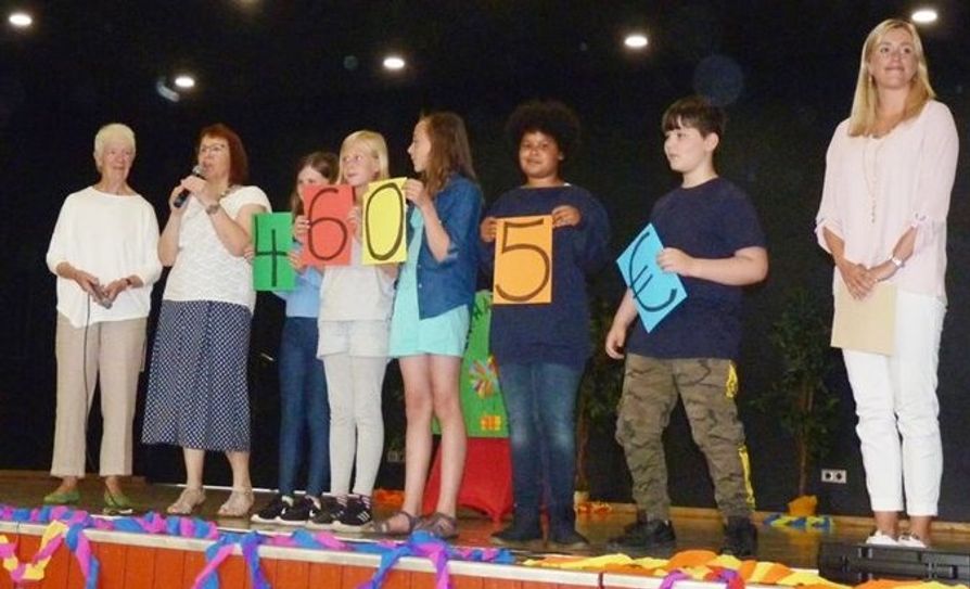 Margret Ringies von Unicef, Schulleiterin Karina Kögel-Renken und Lehrerin Sina Krause mit ihren Schüler/innen bei der Spendenübergabe. Foto: akl