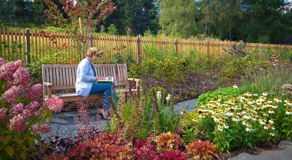 Freiraum zum Entspannen an einem schönen Sommerabend: Eine gemütliche Holzbank rundet den romantischen Garten ab. Foto: djd/GD Holz/www.photostudio3.de