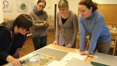 Die Papierrestauratorin Jutta Keddies M.A., FSJ-lerin Nele Stelljes, Kunstwissenschaftlerin Karina Zubkowski M.A. und Museumsleiterin Ellen Horstrup M.A. (v.l.n.r.) betrachten einen Kupferstich mit dem Licht einer Speziallampe.  Foto: eb