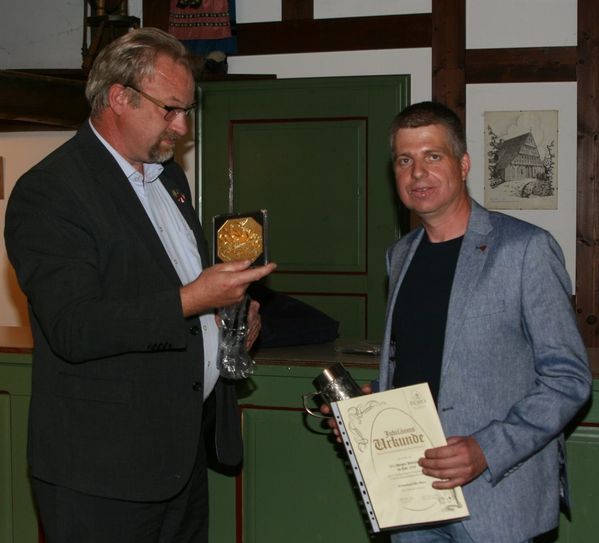 Der Vorsitzende des Landesverbandes Hannoverscher Rassegeflügelzüchter, Alfred Karl Walter (l.) überreichte nicht nur Jubiläumsgeschenke; er zeichnete den Kreisvorsitzenden Karsten Oelrich mit der goldenen Ehrennadel seines Verbandes aus. Foto: sla