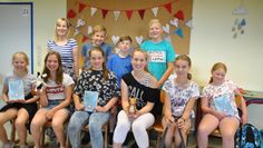 Stolz präsentieren sich ein paar Schüler in Oerel mit der Autorin Stine Oliver (hinten links) und dem Buch „Miep &amp; Moppe“ bei der Lesung. Foto: uml