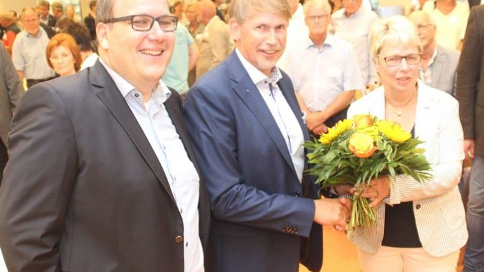 Mit einem Blumenstrauß bedankte sich Wirtschaftsgildesprecher Marco Tulodetzki (Mitte) bei Volker Wahlers (l.) und Marlies Schröder von der Lebenshilfe Bremervörde/Zeven für die Ausrichtung des Sommerfestes.  Foto: im