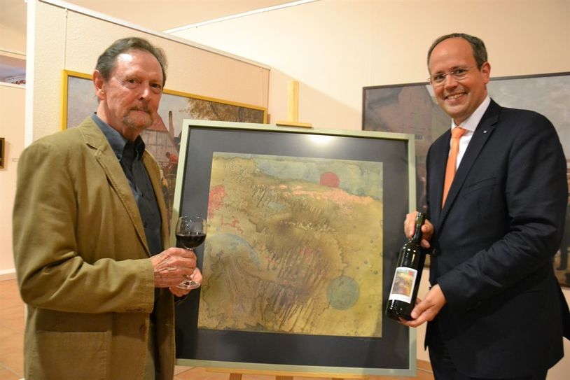 Jan Mackenberg (rechts), Vorstand der Volksbank, und der Künstler Peter J. Lange vor dessen Bild „Der rote Planet“. Foto: ui