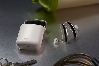 Stylische Modelle gibt es zusammen mit einer kleinen tragbaren Ladestation. Sie ersetzt den Batteriewechsel. Foto: djd/audibene GmbH