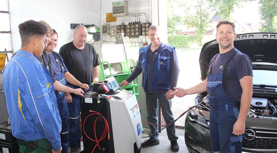 Technisch auf dem neuesten Stand. Hier demonstriert Altgeselle Oliver Kube (rechts) Mitgliedern des Werkstattteams das neue Bi-Gas-Gerät zur Wartung von Pkw-Klimaanlagen.  Fotos: ue