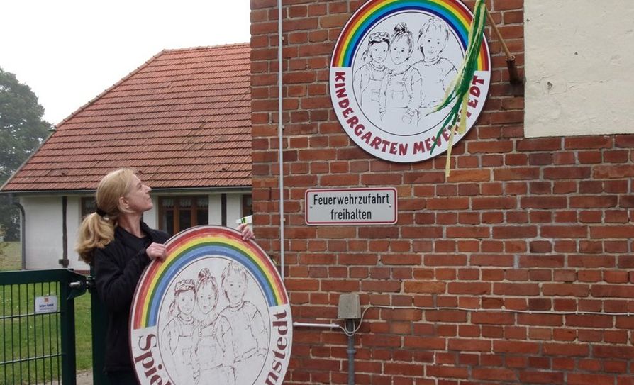 Bei gutem Wetter wurde das neue Kindergartenschild von Marion Wiebke nach einem gemeinsamen Countdown an der Außenwand des Kindergartens enthüllt.  Foto: eb