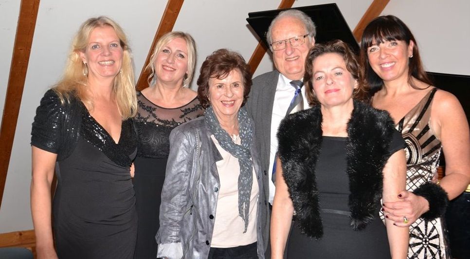 Peter Schwalbe umringt von Frauen. Von links: Pianistin Bettina Fischer, Sängerin Ute Härtel, Ilona Schwalbe, die Sängerinnen Annette Ziellenbach und Larissa Schröder. Foto: ui