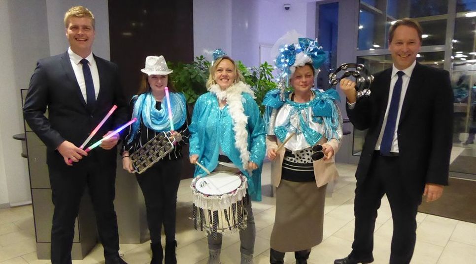 Eingerahmt von den Volksbank-Mitarbeitern Jörn Petersen und Jens Themsen (v.li.) präsentieren Ronja Melzer, Martina de Wolff und Gabi Kaltwasser (v.li.) ihre typischen Samba-Instrumente.  Foto; hc
