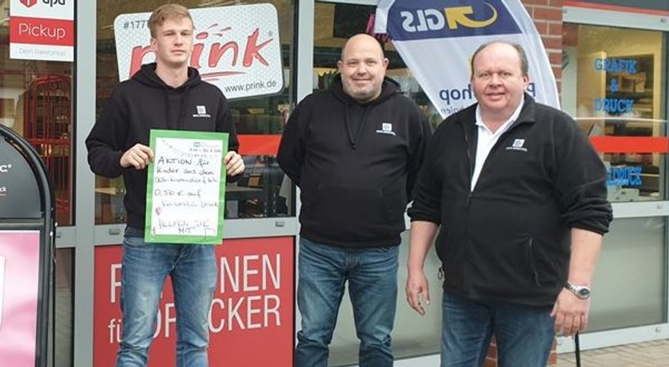 Dirk Lange, (re.), der seit 2015 sein Geschäft Mail Boxes Etc. in Ritterhude mit dem Auszubildenden Pascal Kranz (li.) und Mitarbeiter Enrico Hellmann betreibt, möchte Kindern helfen. Foto: eb