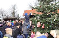 Die Kinder des Regenbogenkindergartens schmücken den Weihnachtsbaum, dafür werden sie vom Weihnachtsmann mit einer kleinen Überraschung belohnt. Fotos: eb