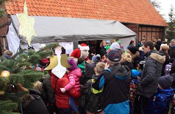 Die Kinder des Regenbogenkindergartens schmücken den Weihnachtsbaum, dafür werden sie vom Weihnachtsmann mit einer kleinen Überraschung belohnt. Fotos: eb