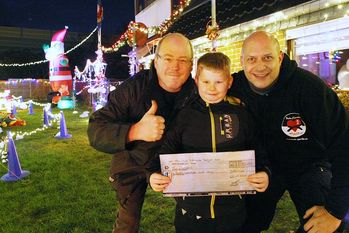 Marco Gevatter (rechts), Botschafter für den Deutschen Kinderverein und Initiator von Budo-Sportler mit Herz, freut sich über die 500-Euro-Spende von Mark Schöttcker, Inhaber von Schöttcker Konzerte, der auch das Weihnachtshaus in der Goethestraße beleuchtet, hier mit Neffe Shawn.  Foto: ek