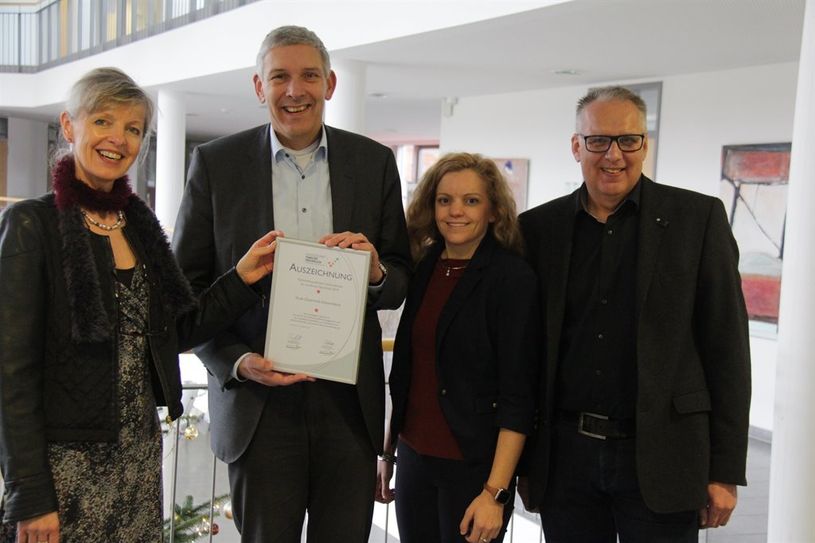 Rena Fehre (links) und Jana Jeske übergaben das Siegel „Ausgezeichnet Familienfreundlich“ an Bürgermeister Torsten Rohde (links) und Fachbereichsleiter Rolf Wehlers.  Foto: jm