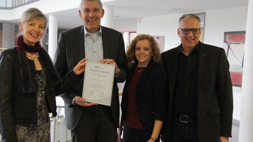 Rena Fehre (links) und Jana Jeske übergaben das Siegel „Ausgezeichnet Familienfreundlich“ an Bürgermeister Torsten Rohde (links) und Fachbereichsleiter Rolf Wehlers.  Foto: jm