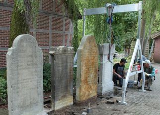 Die Fundamente der gereinigten Grabsteine werden von den Spezialisten vor der Umlagerung vorsichtig freigelegt.  Foto: Bachmann-Museum Bremervörde