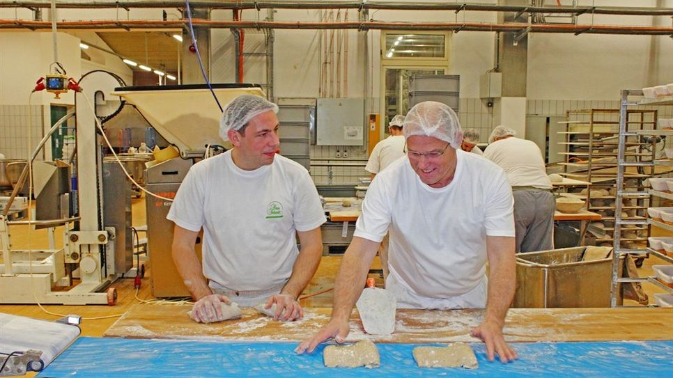 In der Großbäckerei stellen die Bäcker Waldemar und Harald täglich Brote und Brötchen von Hand her.
 Foto: djd/Bäckerei Peter Schmitt