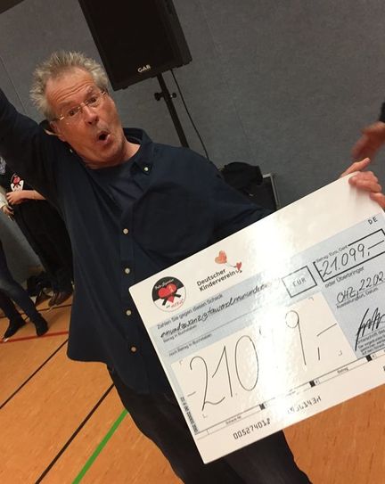 Rainer Rettinger präsentiert stolz den Scheck über 21.099 Euro, die nun Kindern in Not zugutekommen sollen. Foto: eb