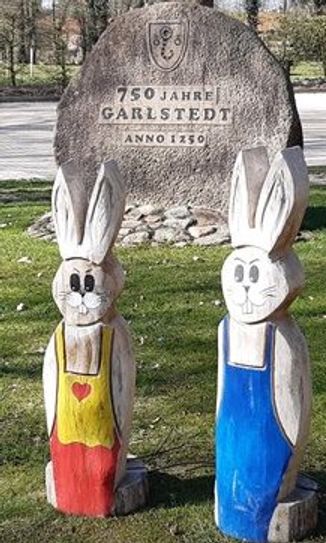 Immun gegen Tröpfcheninfektion, halten diese Holzhasen am Ortseingang in Garlstedt aufmunternd die Stellung.  Foto: eb
