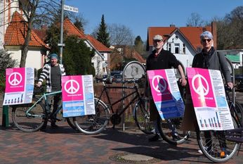 Fritz Böhm, Eckhard Schlöbcke und Anke Beyer (v. li.) präsentieren auf dem Scharmbecker Marktplatz die Ostermarsch-Aktion „Geld für Gesundheit statt für Rüstung. Foto: eb