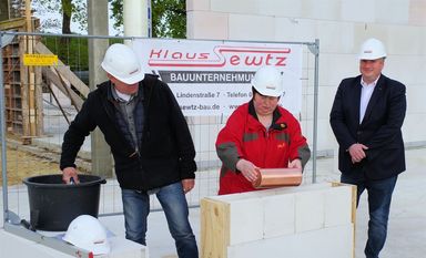 Beton will gut gerührt sein: Architekt Andreas Pigge, Bürgermeisterin Angela Greff und Patrick Grotheer, Geschäftsführer des DRK Osterholz (v. li.) bei der Grundsteinlegung einer neuen KITA. Foto: eb