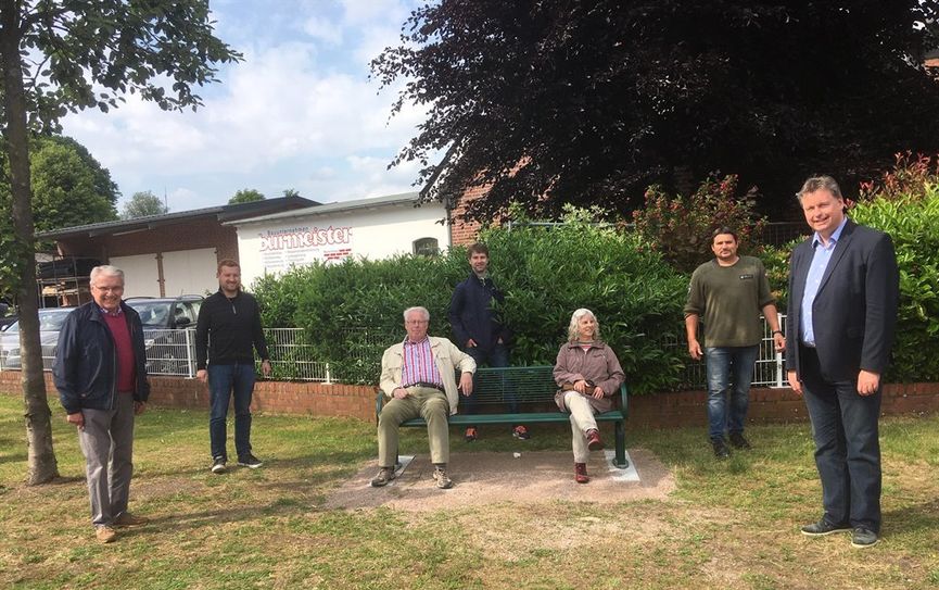 Das Foto zeigt die Ortsratsmitglieder (v.l.) Uwe Matthias, Dirk-Frederik Stelling, Herbert Bardenhagen, Christian Oetjen, Petra Fischer, Marco Wettlaufer und Ortsbürgermeister Frank Pingel an der neuen Bank an der Abzweigung „Am Bahnhof Süd“ .  Foto: eb