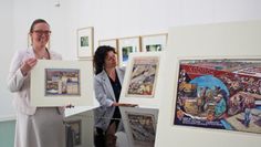Corinna Facktor von der Fielmann Filiale aus Osterholz-Scharmbeck und Beate Arnold vom Barkenhoff präsentierenn die Plakatenwürfe Heinrich Vogelers aus den 1930er Jahren. Foto: pvio