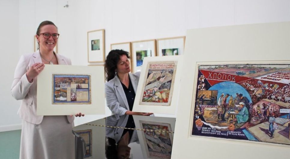 Corinna Facktor von der Fielmann Filiale aus Osterholz-Scharmbeck und Beate Arnold vom Barkenhoff präsentierenn die Plakatenwürfe Heinrich Vogelers aus den 1930er Jahren. Foto: pvio