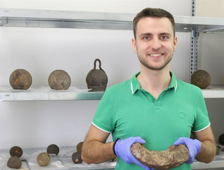 Historiker Andreas Schley mit einem Bruchstück einer hohlen Bombe. Hinter ihm sind Kanonenkugeln aus den Sammlungen des Bachmann-Museums zu sehen, die derzeit erforscht werden.
Foto: Bachmann-Museum
