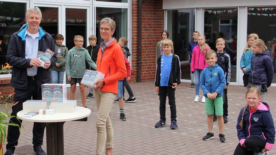 Es ist eine Kooperation, die seit über 15 Jahren Bestand hat: Schulleiter Helmut Winkelmann und die Kinder des vierten Jahrganges der Grundschule Selsingen freuten sich über die Buchspende, die Sabine Wülpern vom Spielparadieses Wülpern  im Gepäck hatte.  Foto: ue