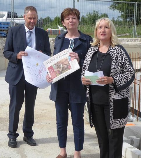 Susanne Geils, Marion Schorfmann und Arno Seebeck (v.re.) präsentieren den Inhalt der Dokumentenhülse, die im Fundament des Faulturms einbetoniert wurde.  Foto: hc