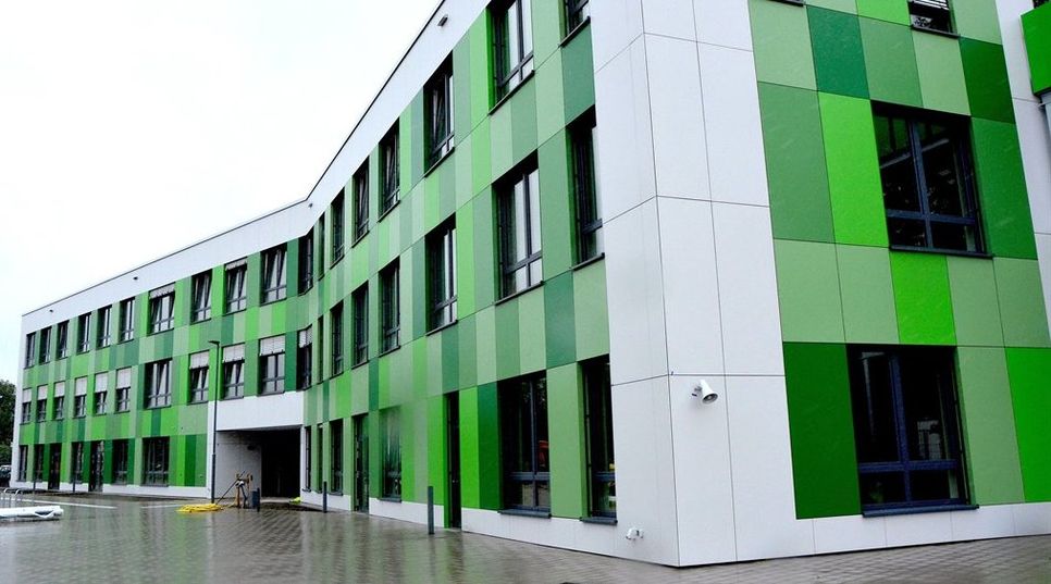 Das imposante Schulgebäude zeigt sich hier von seiner grünen Seite. Aber auch rote und blaue Gebäudeabschnitte hat der neue Campus zu bieten. Fotos: rgp