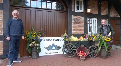 Georg Erasmi und Werner Soller (von links) vom Heimatverein legen bei der Dekoration vor dem Küsterhaus letzte Hand an.  Foto: hc