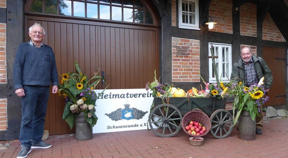 Georg Erasmi und Werner Soller (von links) vom Heimatverein legen bei der Dekoration vor dem Küsterhaus letzte Hand an.  Foto: hc