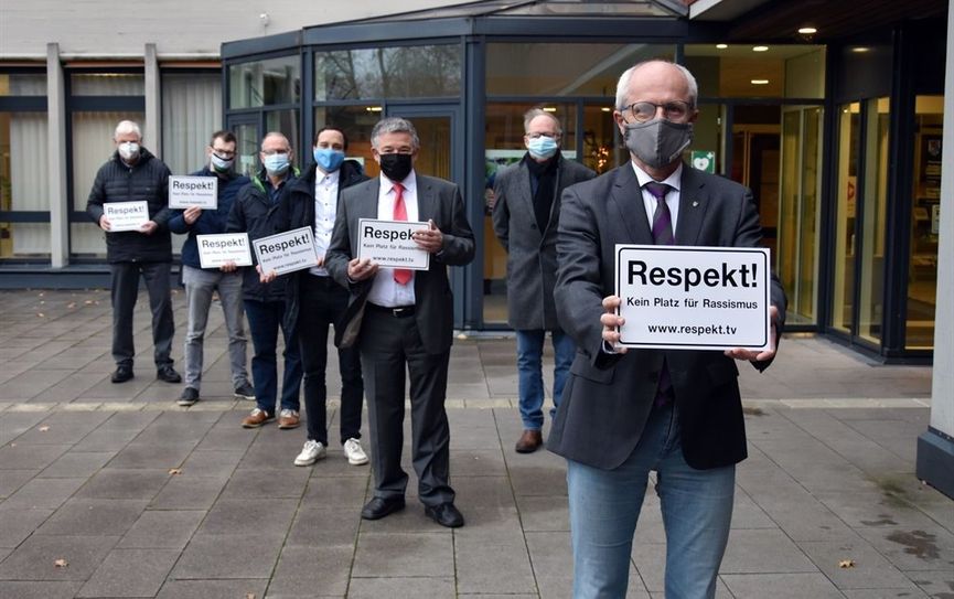 V.l.: Lothar Cordts (SPD), Matthias Kröger (parteilos), Claus Aselmann (CDU), Nils Bassen (SPD), Reinhard Lindenberg (WFB), Heinz-Friedrich Carstens (CDU), Landrat Hermann Luttmann mit den Schildern vor dem Rotenburger Kreishaus.  Foto: eb