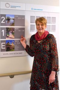 Kerstin Rihm am Wegweiser - alle Bereiche sind nach Orten der Umgebung benannt.