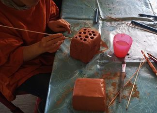 Kinder fertigen mit unterschiedlichen Hilfsmitteln Nisthilfen für Wildbienen an. Foto: Helga-Leinung-Schule