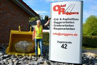 Olaf Riggers vor der symbolischen Baggerschaufel an der Auffahrt zum Betriebsgelände in Brillit